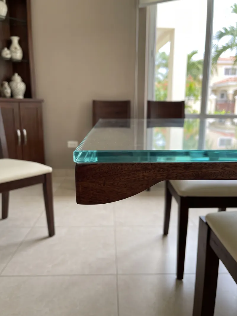 Detalle del borde pulido de un tope de vidrio sobre una mesa de comedor
