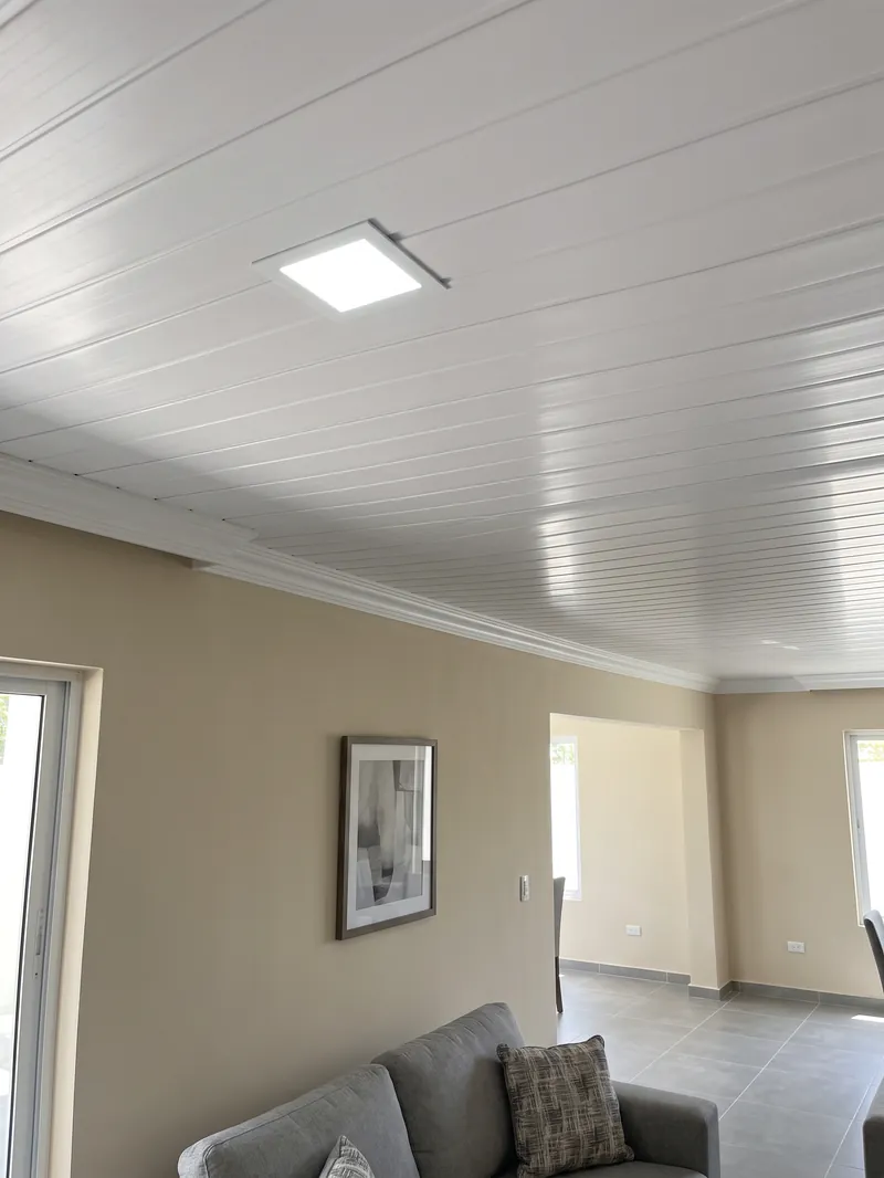 Plafón de PVC blanco terminado en el techo de una sala