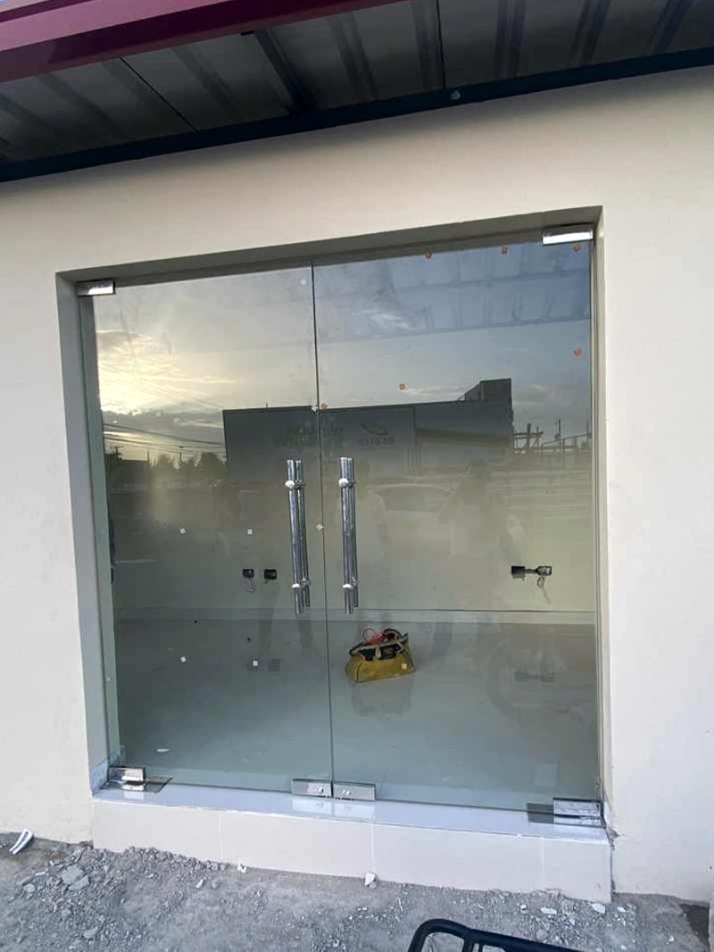 Frente de local comercial en vidrio con puertas batientes